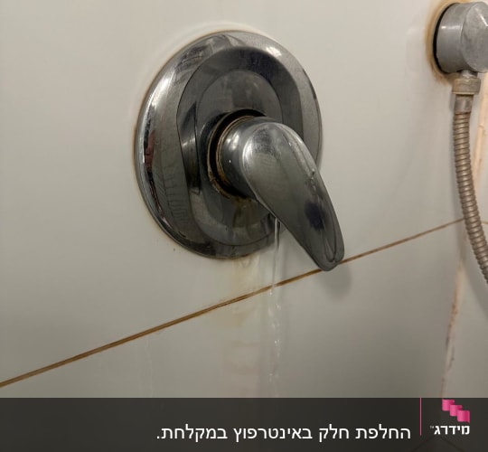 ברז מים דולף עם ידית מתכת בחדר אמבטיה